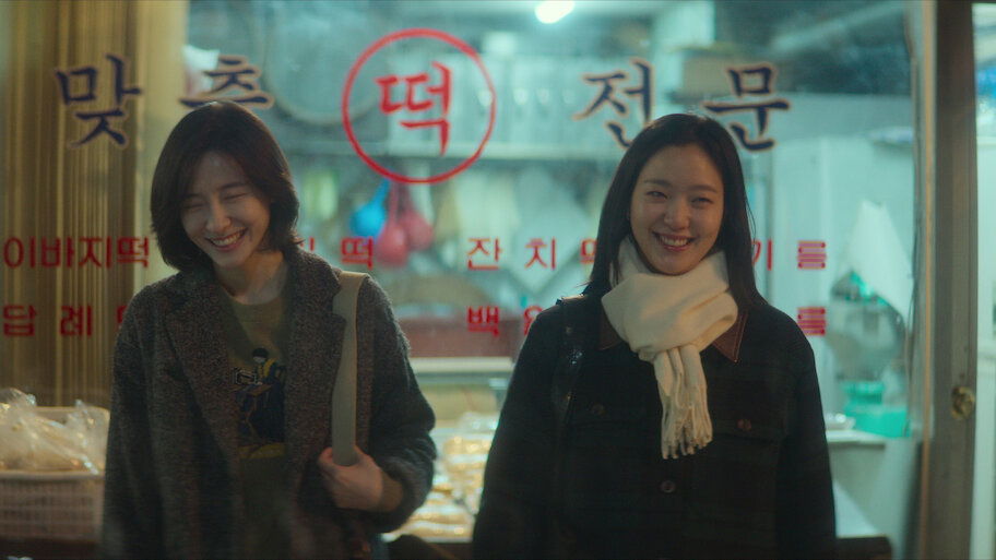 Two women smiling outside a store