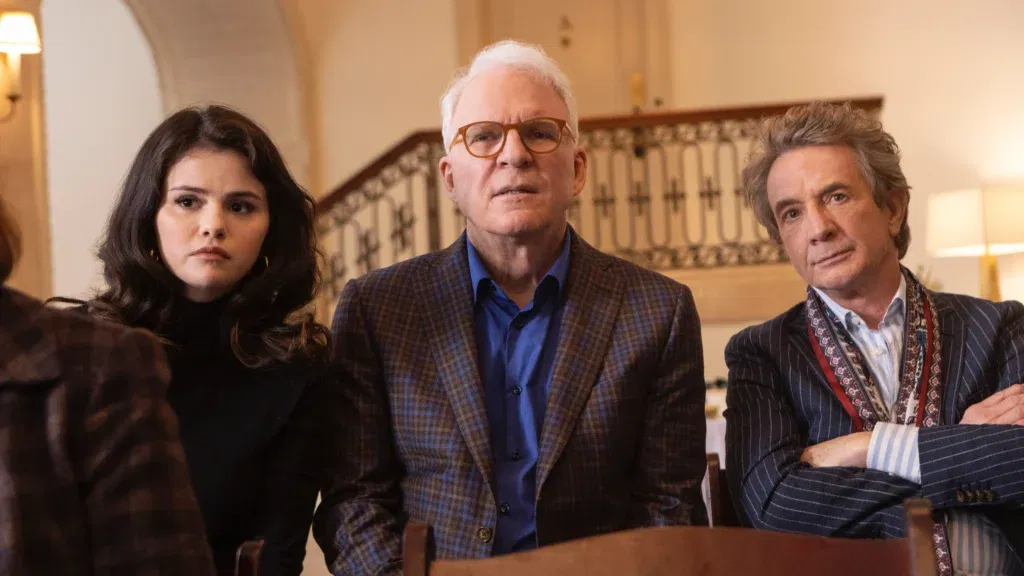 Selena Gomez, Steve Martin and Martin Short are standing and staring ahead