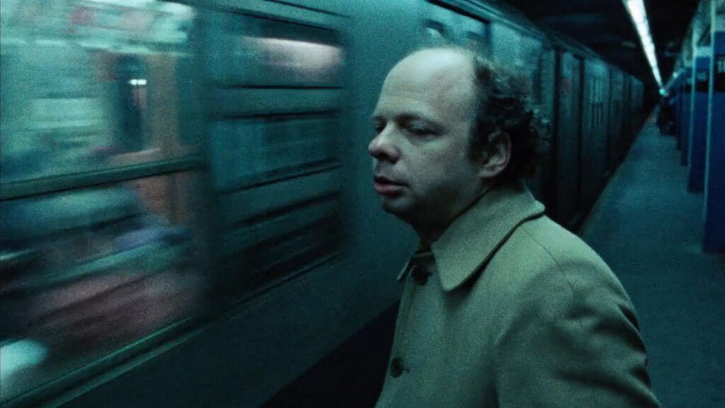 A character looking at a passing train in My Dinner With Andre