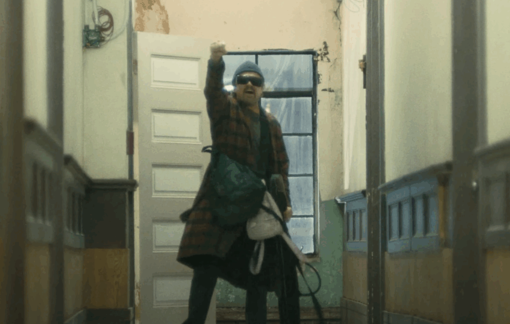 Leonardo Dicaprio yelling out a slogan in One Battle After Another