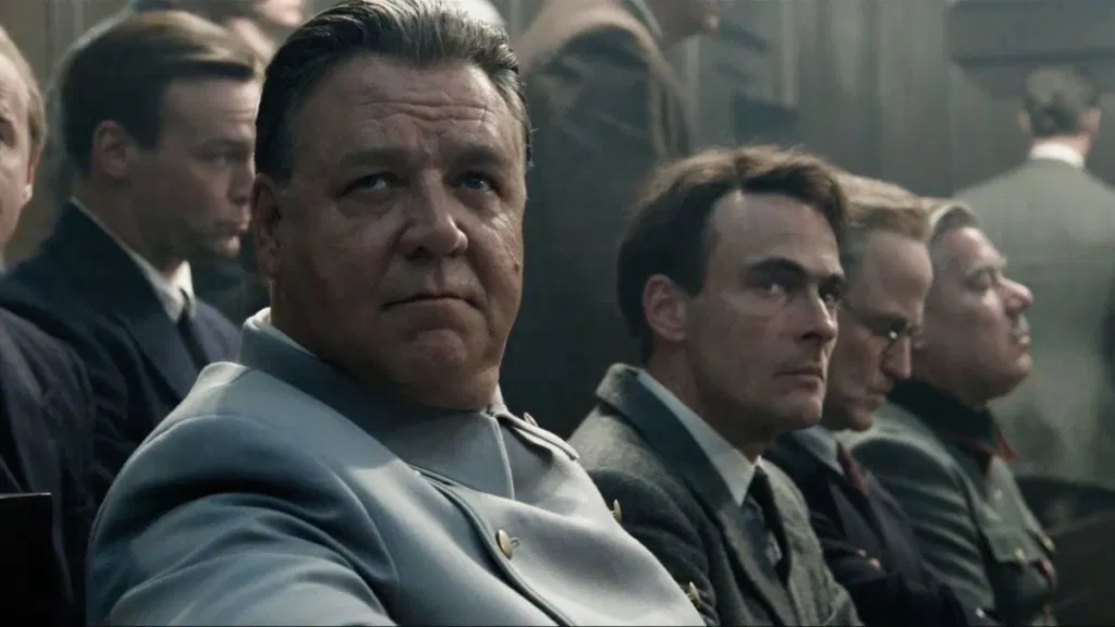 Russell Crowe looking to his right with intensity in a still from Nuremberg