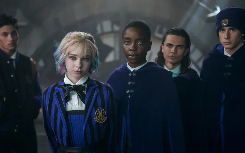 Oliver Watson, Noah B. Taylor, Emma Myers, Georgie Farmer, and Joy Sunday standing together looking stern in Wednesday