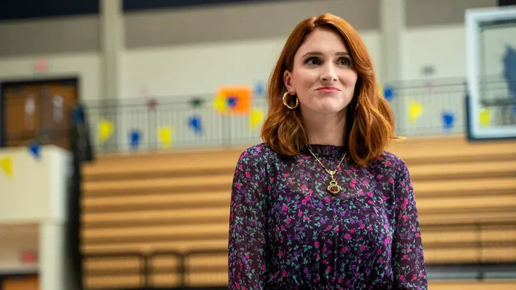 A smiling woman in a purple top