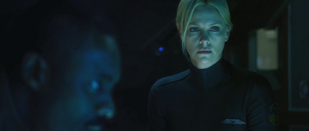 Charlize and Idris Elba look at a screen