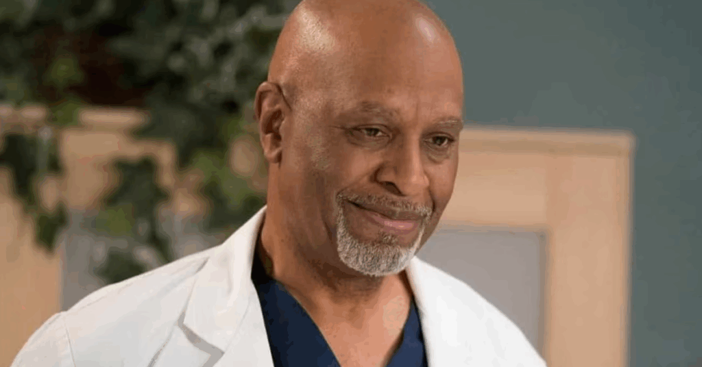 James Pickens Jr. in a scrub smiling at someone. 