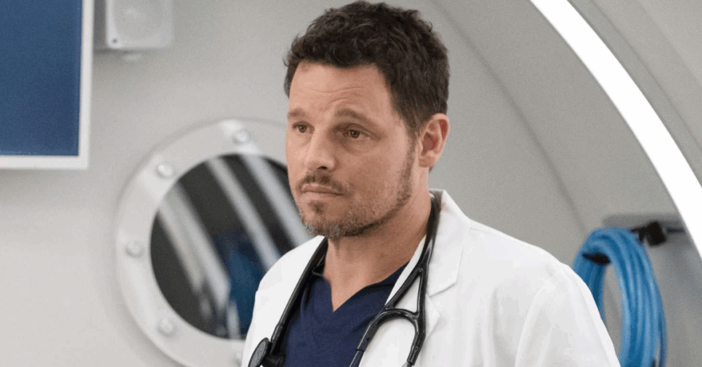 Alex Karev looking stressed at someone while wearing his scrubs. 