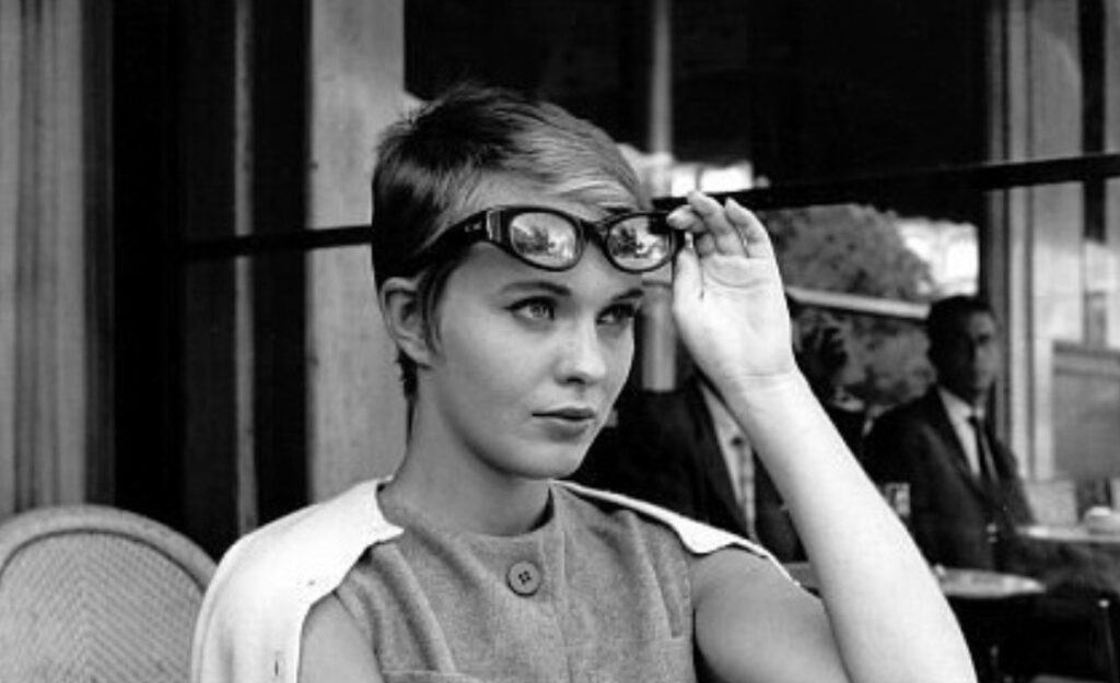 Jean Seberg holding her glasses up