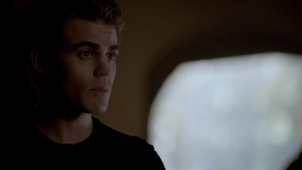 Paul Wesley as Silas with dark hair in a dimly lit indoor setting, photographed in profile with dramatic lighting.