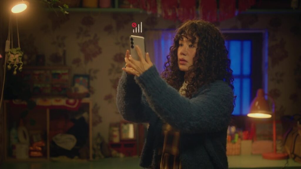 Se-ra holding her phone in a still from My Troublesome Star