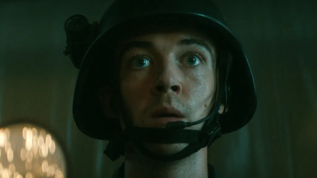 Alex Lawther looks at an alien