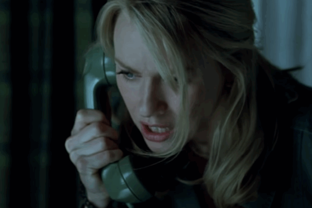 A blonde woman, talking on a phone.
