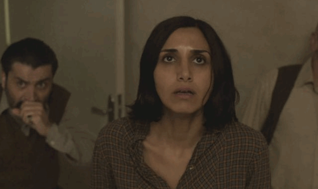 A woman with short hair, looking up at the ceiling in Under the Shadow.