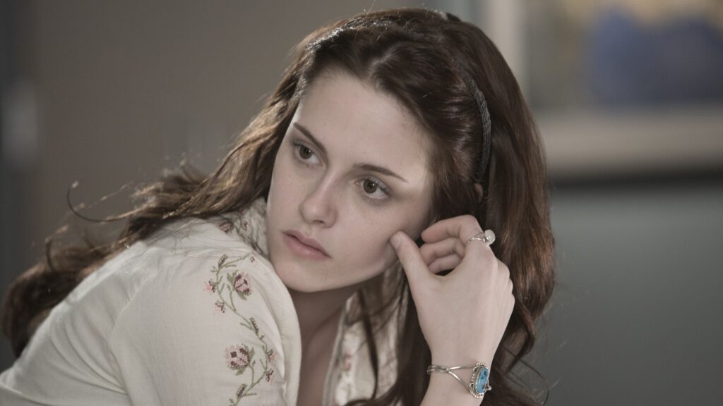 Bella (Kristen Stewart) with a headband and floral top during a quiet moment from the first Twilight movie.