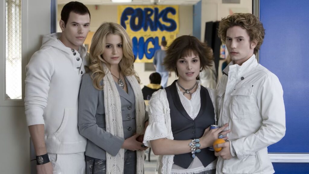 The Cullen family kids — Emmett (Kellan Lutz), Rosalie (Nikki Reed), Alice (Ashley Greene), and Jasper (Jackson Rathbone) — stand together in the hallway of Forks High School, with "FORKS" visible on a banner behind them.