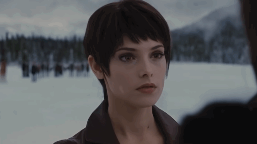Alice Cullen (Ashley Greene) with her distinctive short dark hair looks intensely at Aro (Michael Sheen) off-camera in a snowy setting, during her final battle prophetic vision showing.