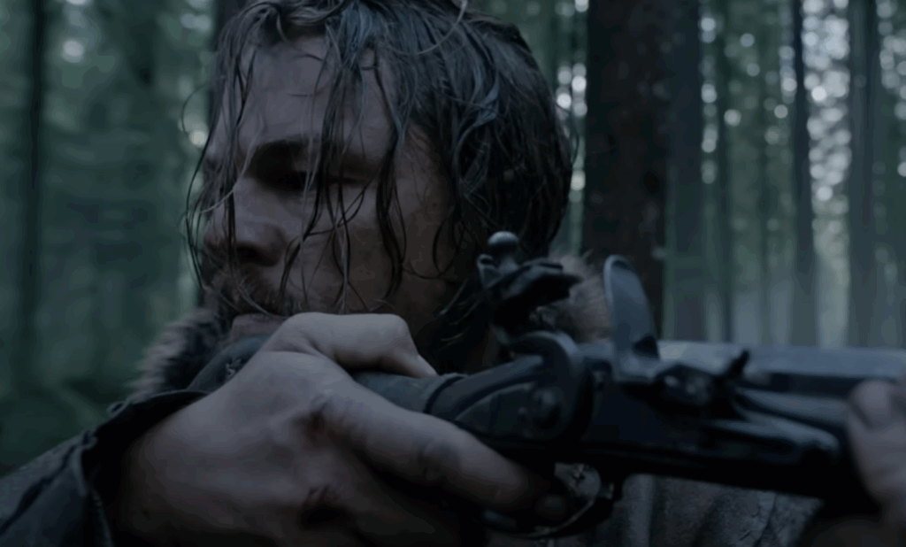 Leonardo DiCaprio with wet hair, holding a rifle in his hands. 
