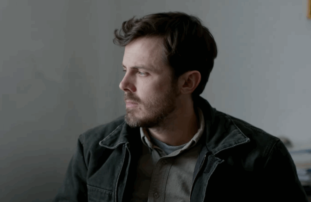 Casey Affleck in a black jacket and beard. 