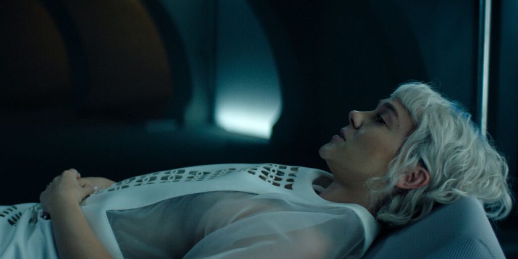 Synnøve Karlsen lying down in a white dress in Foundation season 3