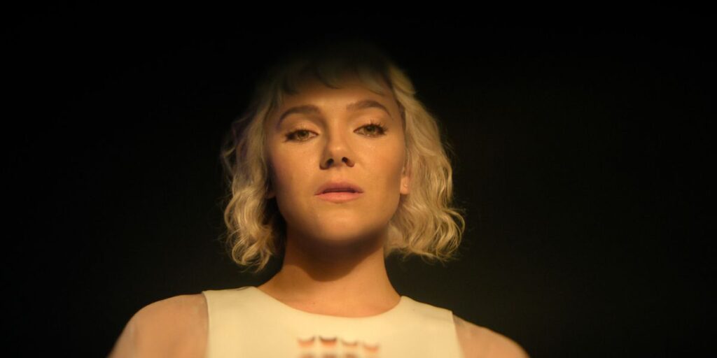 Close up of Synnøve Karlsen looking smug in a white dress in Foundation season 3 finale