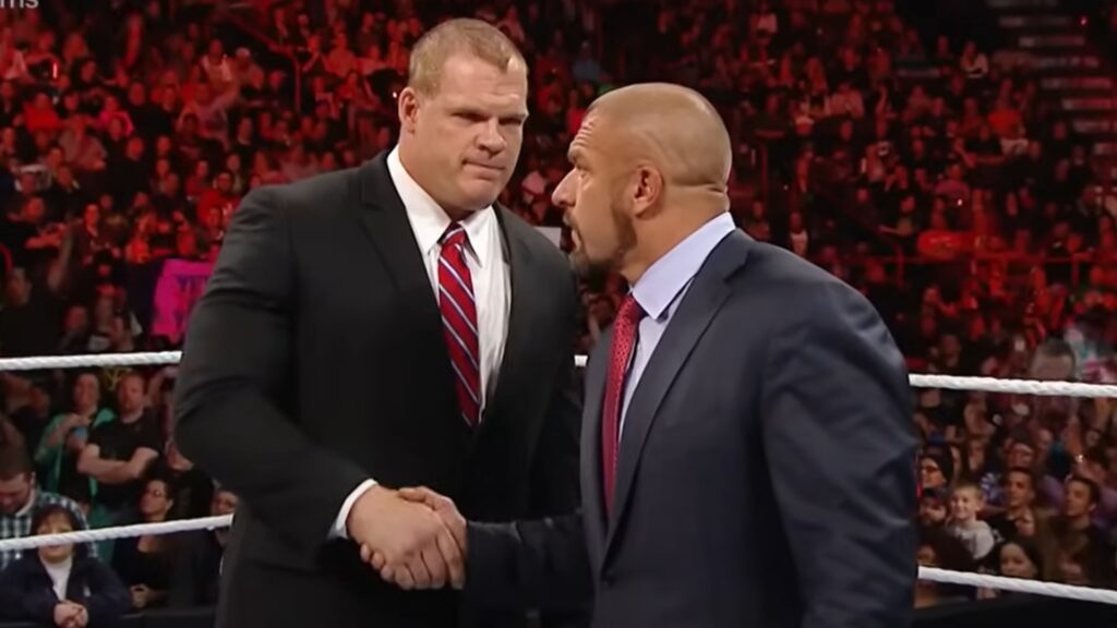 Kane and Triple H shaking hands and settling a dispute