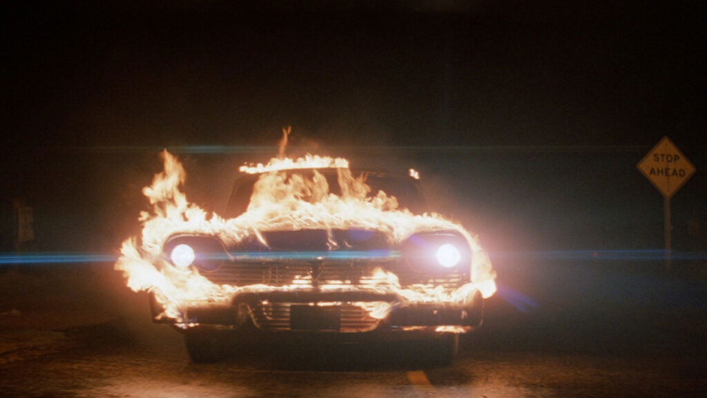 A shot of the car, Christine, on fire in the 1983 John Carpenter film adaptation.