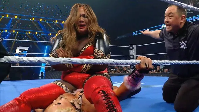 Nia Jax sitting on top of Tiffany Stratton