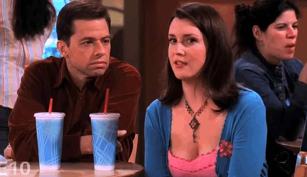 Rose is sitting at a table with Alan and two blue drinks with red straws.