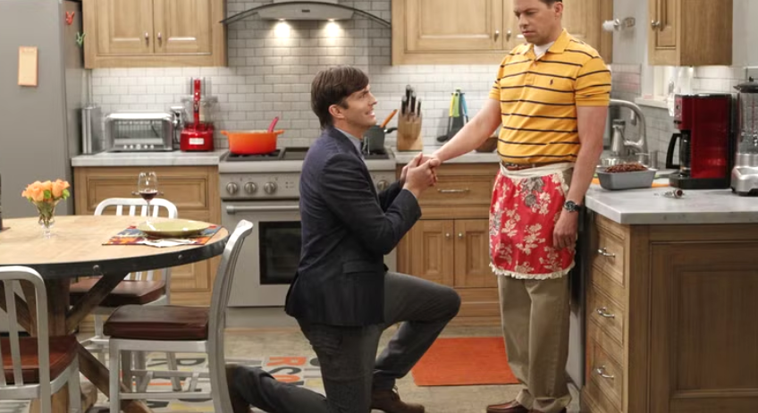Walden Schmidt is kneeling on one knee, holding Alan Harper's hand.