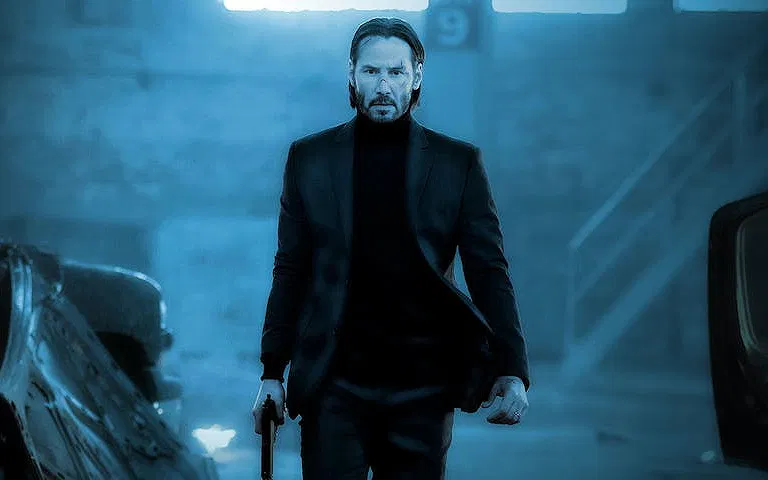 John Wick walking with a pistol in hand