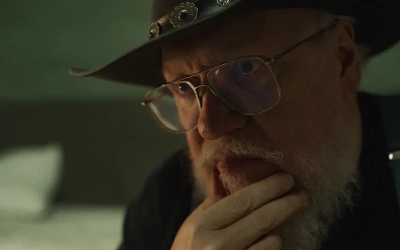 George R.R. Martin looking with his hand on his chin