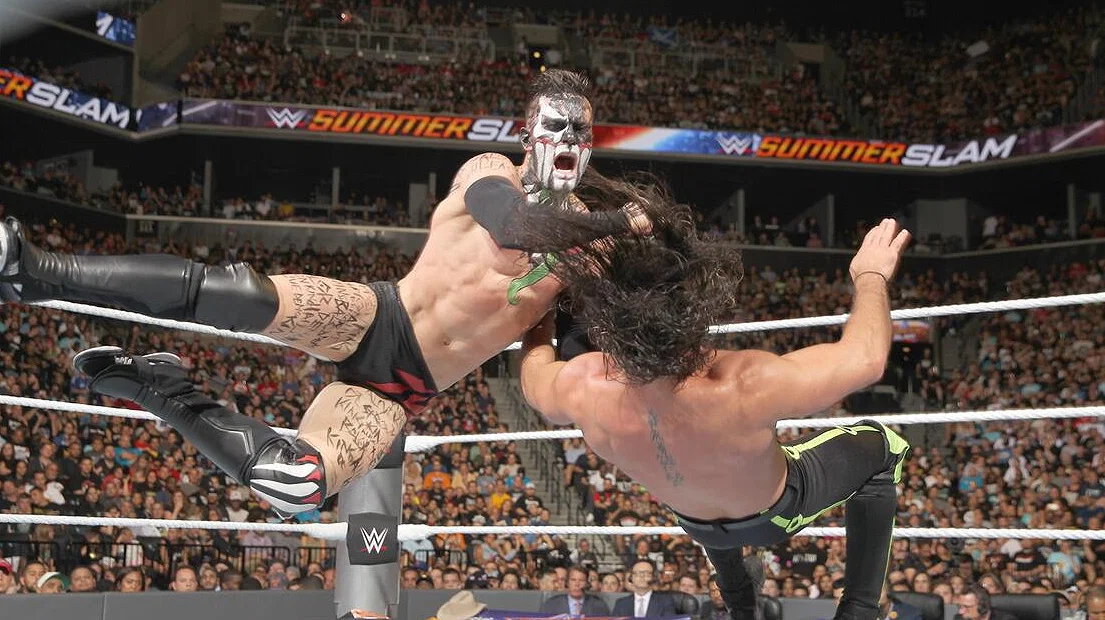Finn Bálor delivering a Swing Blade to Seth Rollins