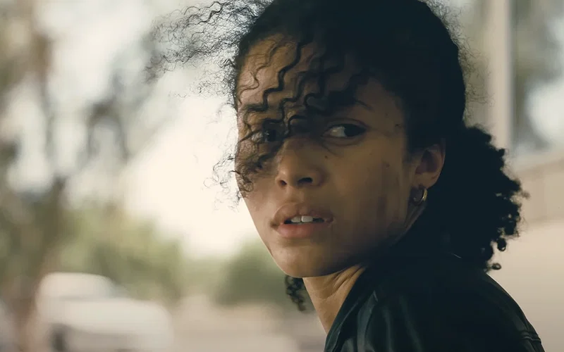 Willa, sitting alone with her hands tied in One Battle After Another.