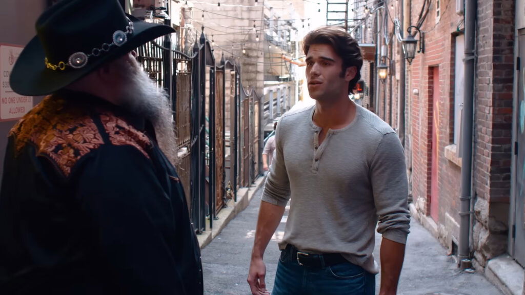 a muscular man talking to a bearded man who kinda looks like a santa-claus.