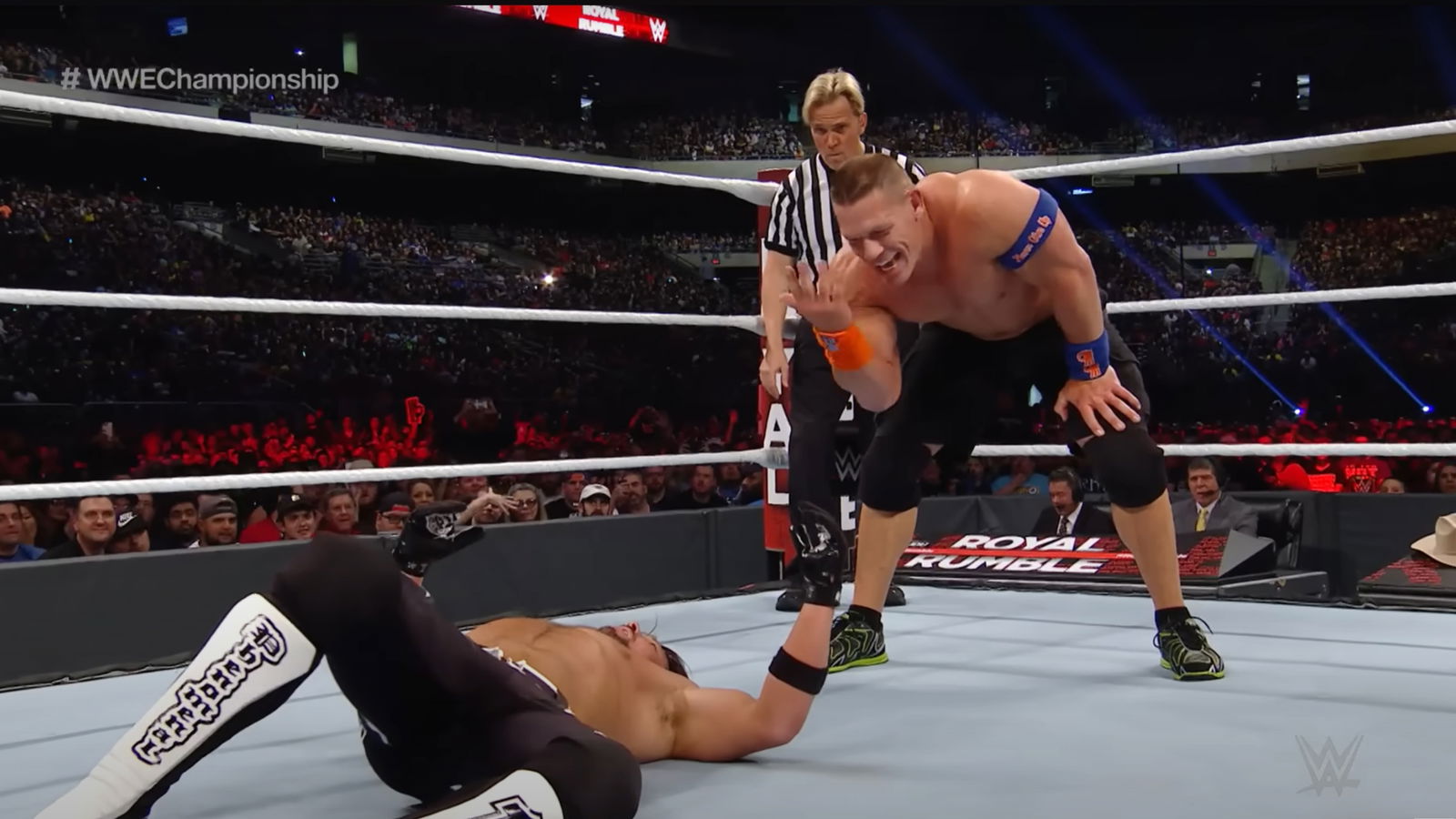 John Cena with his signature You Can't See Me gesture to AJ Styles