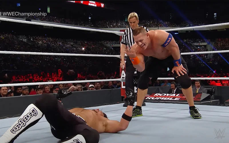 John Cena with his signature You Can't See Me gesture to AJ Styles