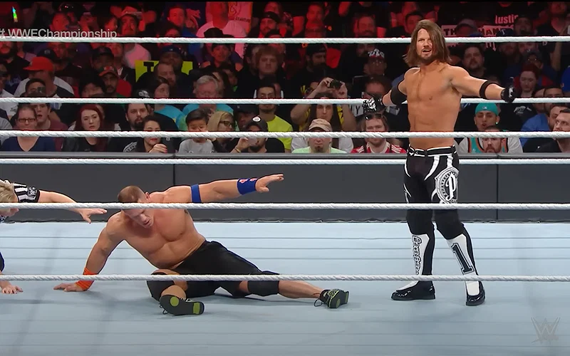 John Cena recovering during a match against AJ Styles