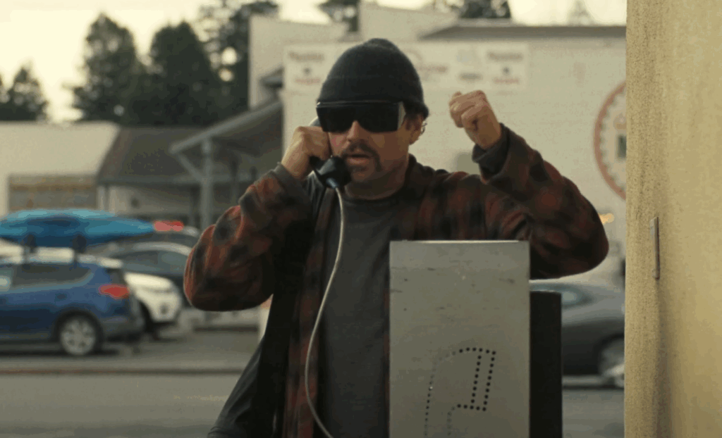 Leonardo DiCaprio's Bob using a public phone boot in in One Battle After Another. 