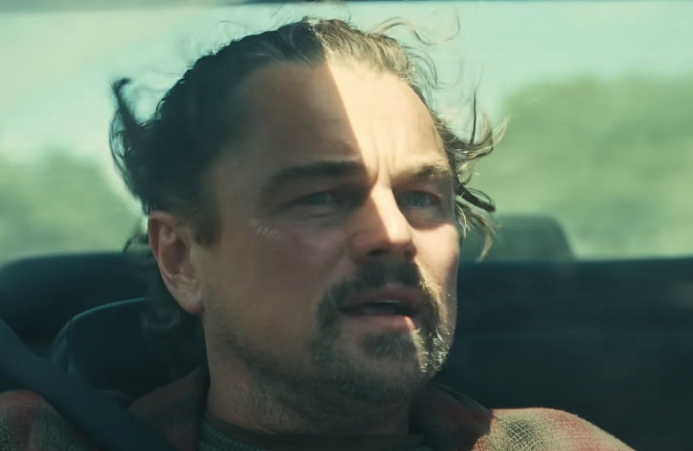 Leonardo DiCaprio's Bob sitting in a convertible car in One Battle After Another. 