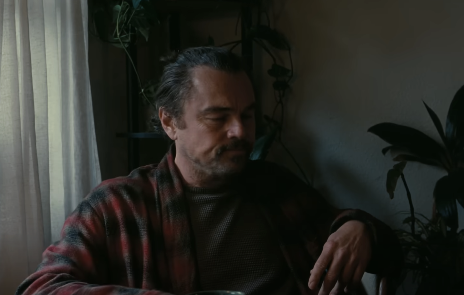Leonardo DiCaprio's Bob wearing a chequed robe in One Battle After Another. 