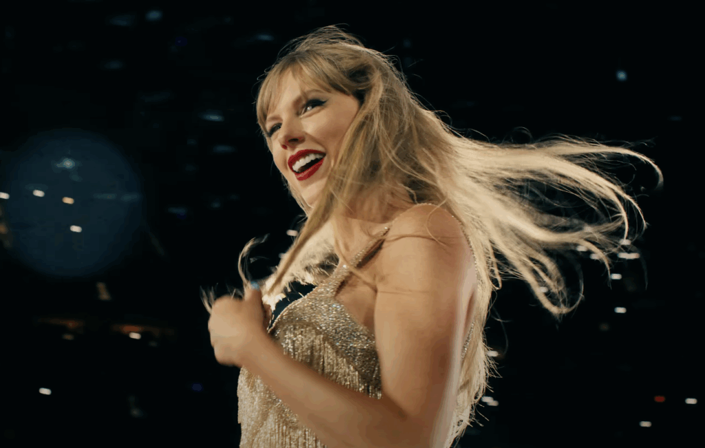 Taylor Swift in a golden dress, performing at the Eras tour. 