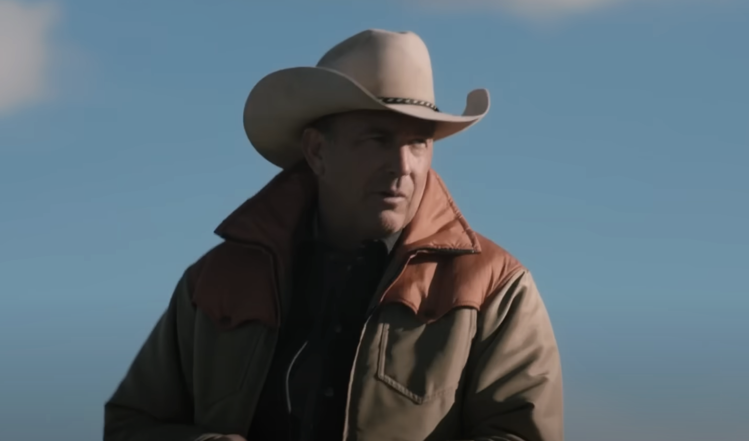 Kevin Costner wearing a cowboy hat and riding a horse in Yellowstone. 