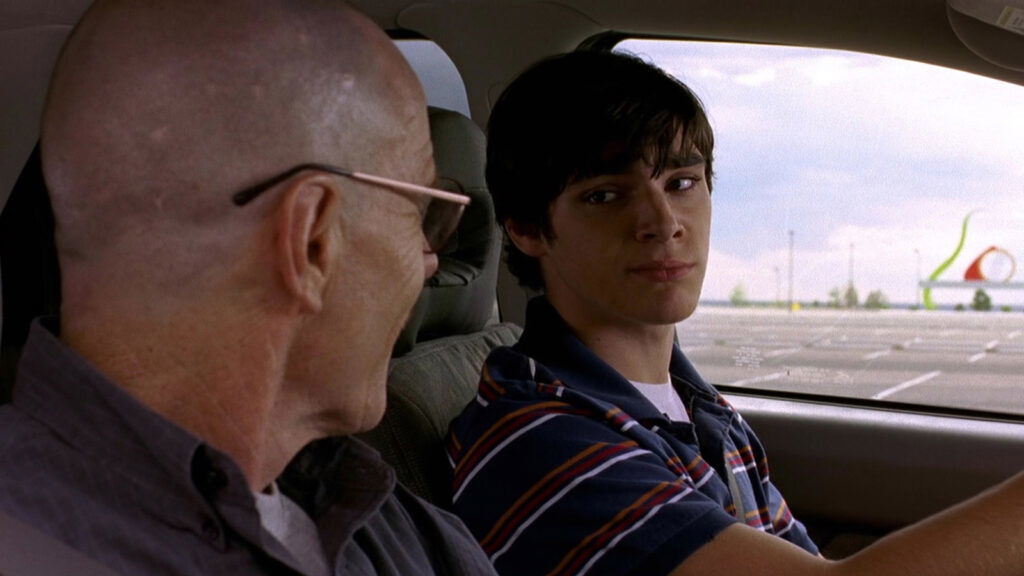 rj mitte sitting in the driver's seat in Breaking Bad alongside Bryan Cranston's Walter White Jr.
