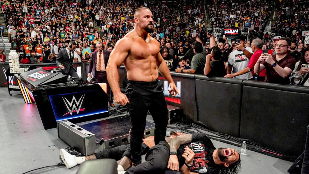 Bron Breakker towering over Roman Reigns