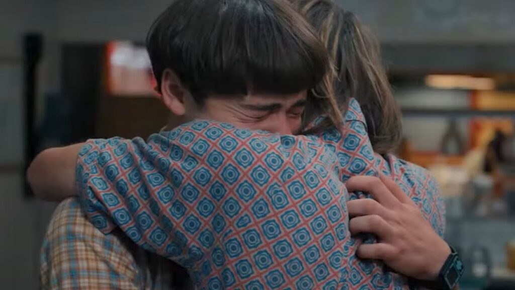 Will Byers (Noah Schnapp) and Jonathan Byers (Charlie Heaton) embracing emotionally, both appearing very upset.