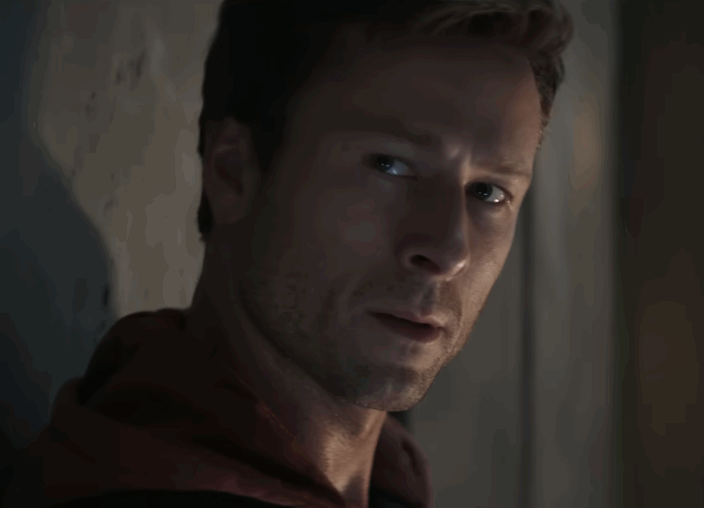 Glen Powell Confirms His Batman Future in The DCU After Initial Rumors 1 Glen Powell in a red hoodie in The Running Man.