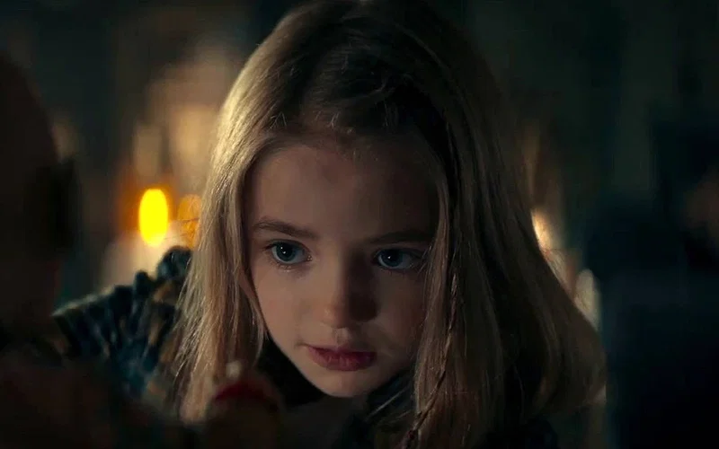 Nell Fisher as Kassie in Evil Dead Rise close-up shot with dramatic lighting and dark background