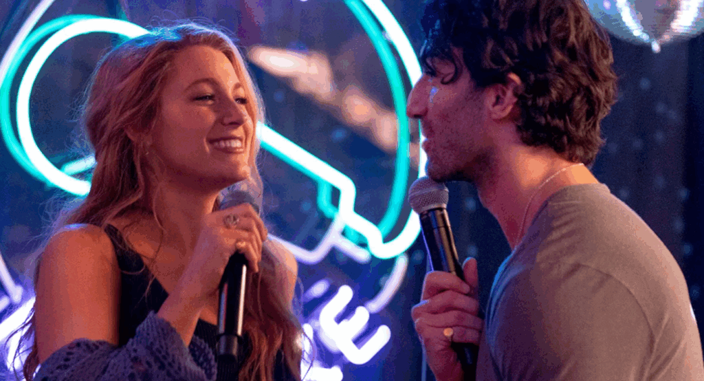 Blake Lively and Justin Baldoni in the movie It Ends With Us are happily singing into microphones together.