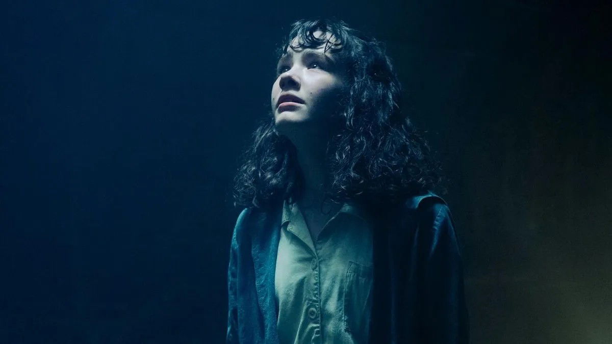 Lilly Bainbridge actress Clara Stack in It Welcome to Derry Season 1 looking upwards, scared, in the dark tunnel