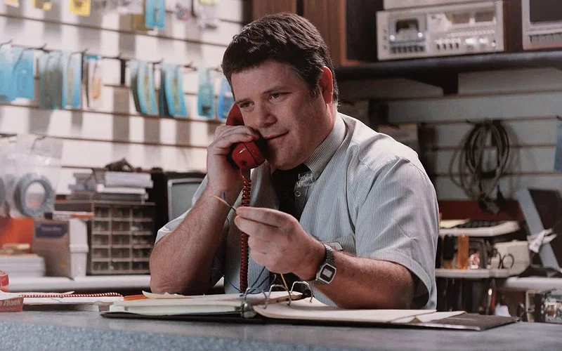 Bob Newby (Sean Astin) working at RadioShack in Stranger Things Season 2 and talking on a phone