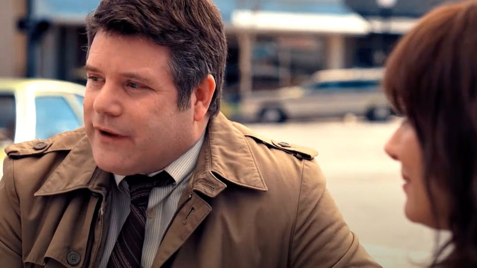 Bob Newby (Sean Astin) talking to Joyce Byers (Winona Ryder) outdoors in Stranger Things